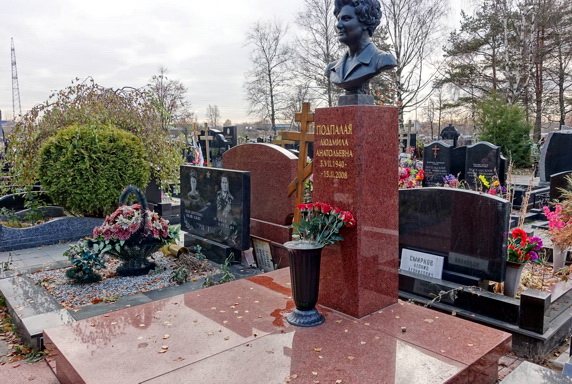 Бюст покойной на высокой прямоугольной стеле из гранита